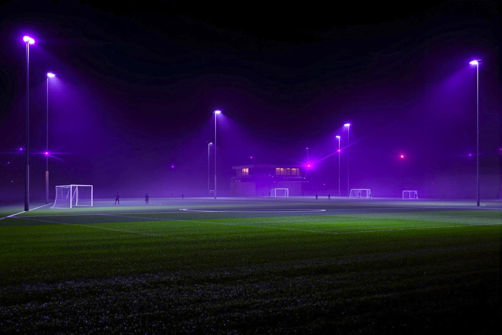 A football academy training ground at night under floodlights.